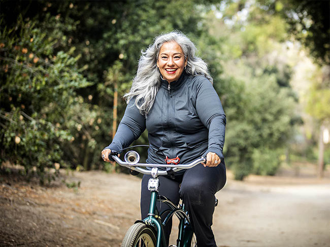 墨西哥高级妇女在骑自行车时微笑着。