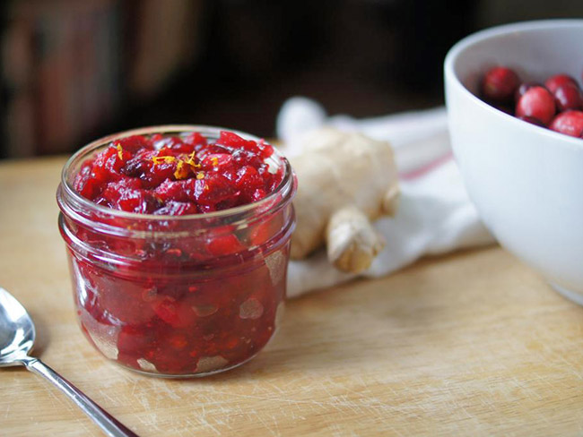 一个罐头罐，里面装满了自制的蔓越莓酱，上面是木桌上的。