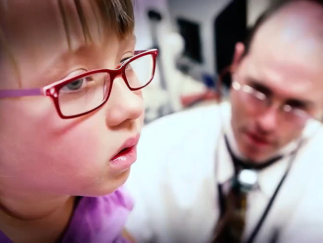 一个蹒跚学步的女孩正在接受医生的检查。
