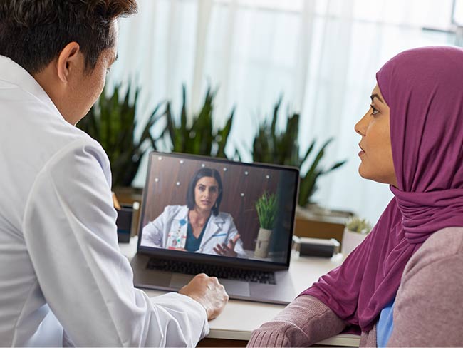 一男一女坐在电脑屏幕前与医生视频通话