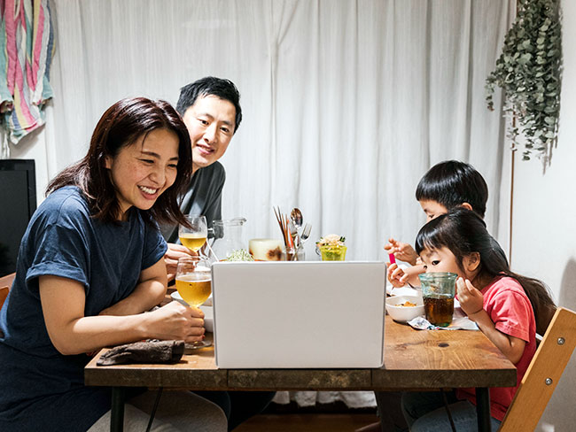 参加在线视频通话和一起享受晚餐的亚洲家庭。