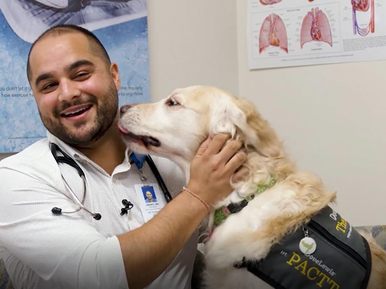 一名男子抚摸一只服务犬，因为它试图舔他的笑脸