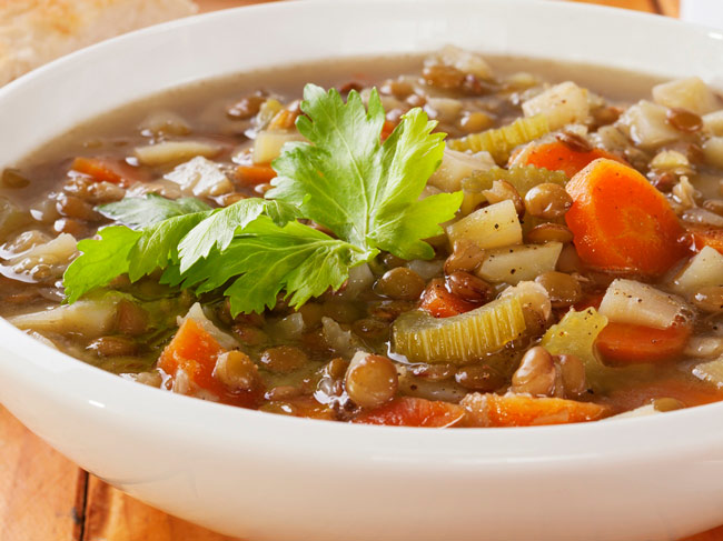 一碗汤，有小扁豆，豆类，切成薄片的胡萝卜和蔬菜。