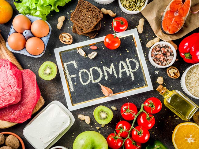 头顶的黑板照片，中间写着“FODMAP”，周围是各种食物，包括西红柿和鸡蛋。