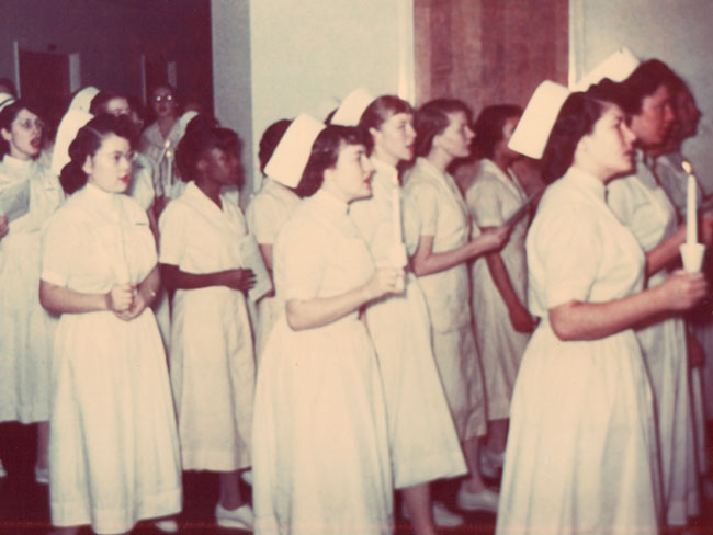 KFSN的学生在毕业典礼上(经过6个月的学习)走过凯撒奥克兰医院，大约在1960年