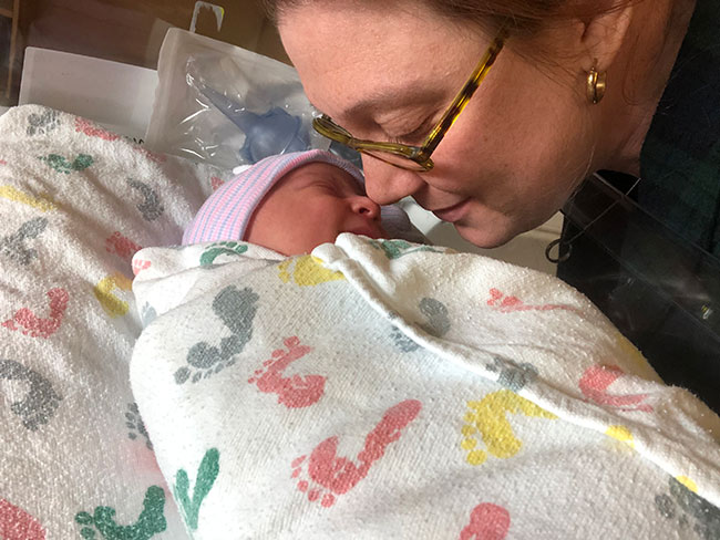 亚历克西娅·罗斯托俯下身去看着新生儿，他们的鼻子碰在了一起。