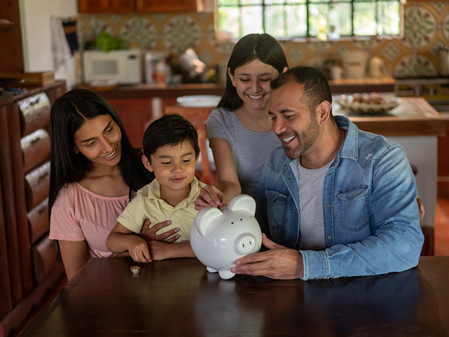 幸福的拉丁美洲家庭在存钱罐存钱
