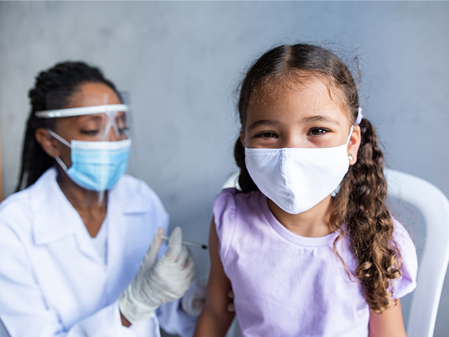小女孩戴着口罩接受疫苗接种
