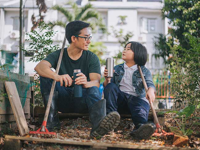 男人和男孩坐在花园里