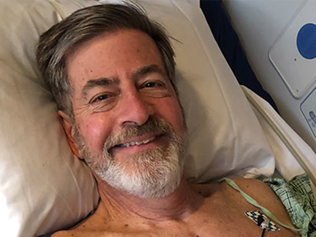 微笑的男人躺在医院的病床上