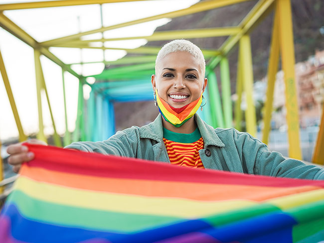 年轻的同性恋女人持有LGBT彩虹旗