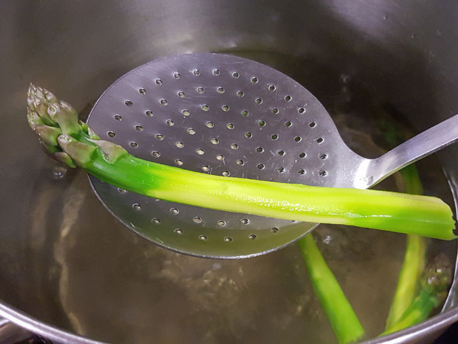 将新鲜的绿芦笋放入高汤中焯水。