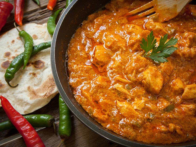 用辣椒在碗上的碗中的红酱中鸡肉。