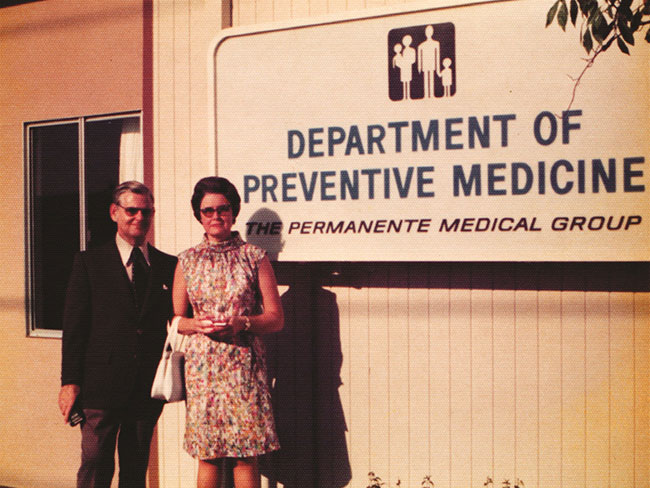 男人和女人站在前面的标志,上面写着:预防医学