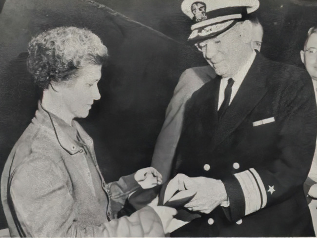 玛丽卡罗尔接受价值旗帜从海军少将霍华德·l·维克瑞7月19日,1942年。