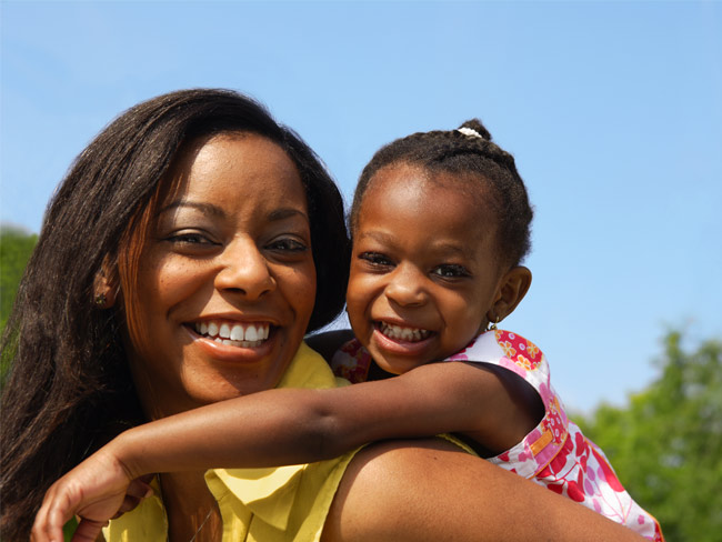 黑人母亲和她的女儿在户外微笑