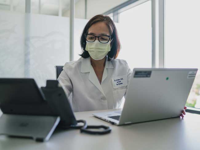 Kaiser Permanente physician with phone and computer at desk