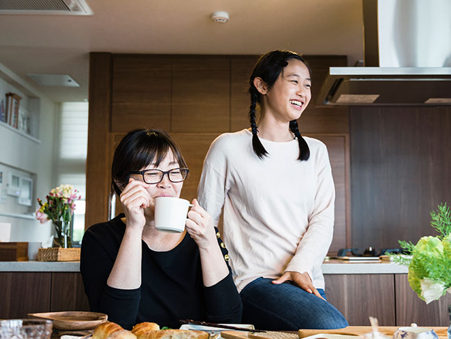 亚洲母亲和女儿在餐桌旁一起吃午餐时很放松。