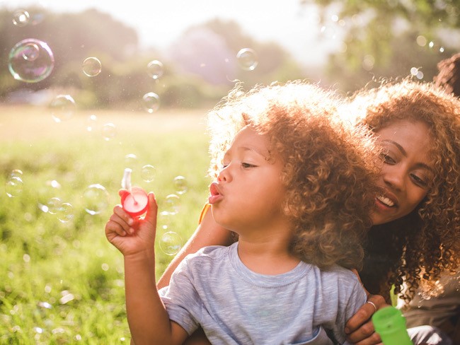 child and mother in grassy field